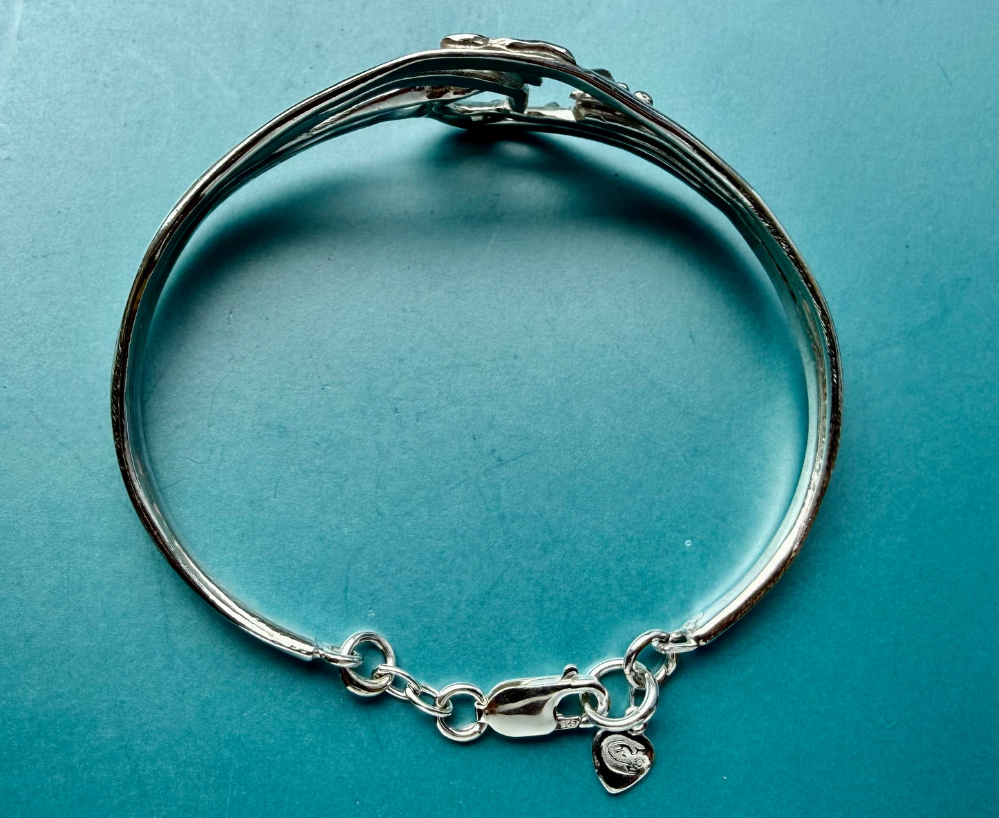Silver wave and seagulls bracelet with a clasp on a blue background