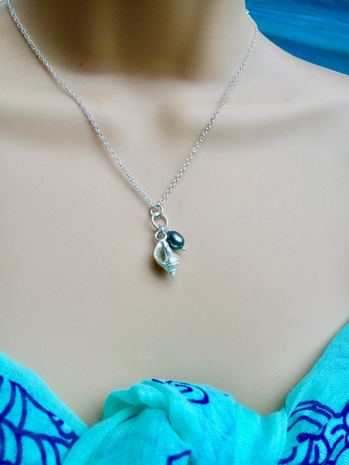 Whelk shell necklace with blue black pearl