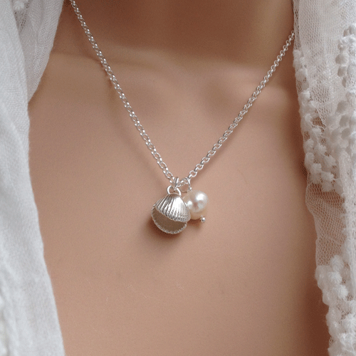 This is a unique solid silver double sided cockle shell necklace