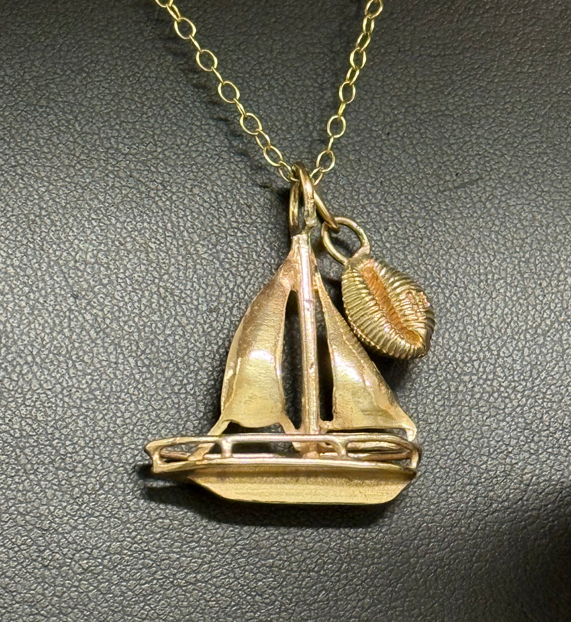 Gold sailing boat with gold cowrie shell charm from Langland Bay Gower.