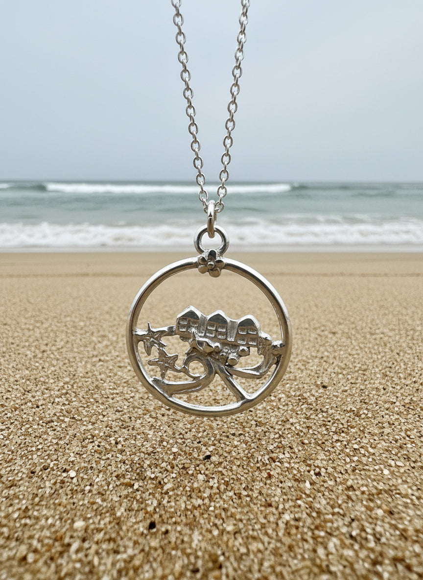 Silver pendant with a beach huts  design with a wave and starfish