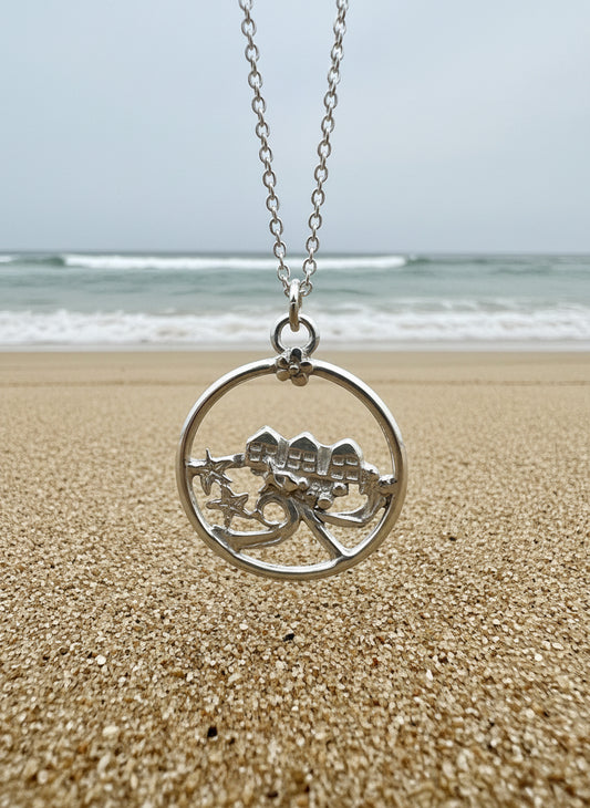 Silver pendant with a beach huts  design with a wave and starfish