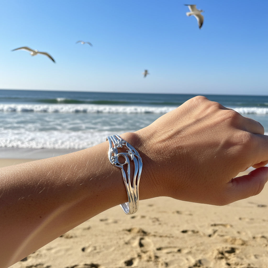 Silver bracelet on a wrist with a light blue background