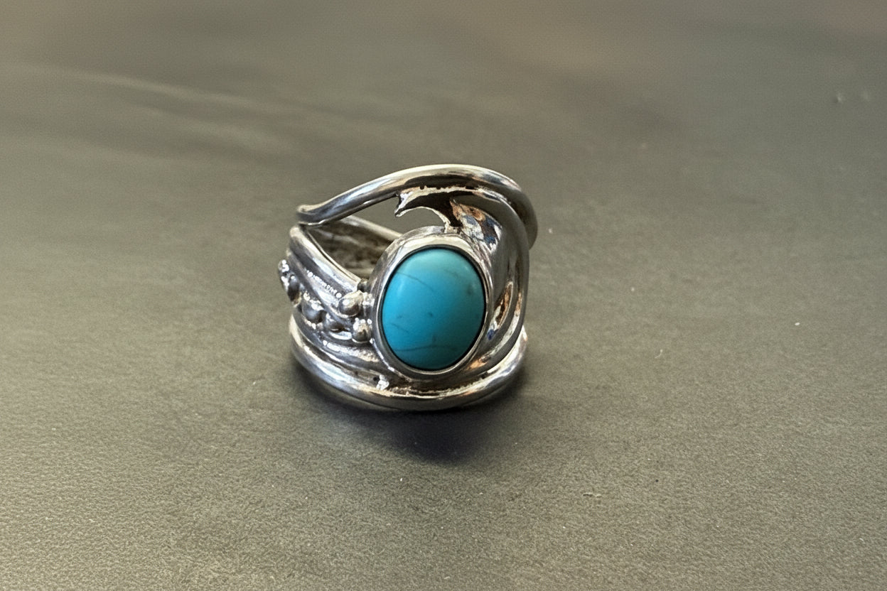 Silver ring with a turquoise stone on a gray background