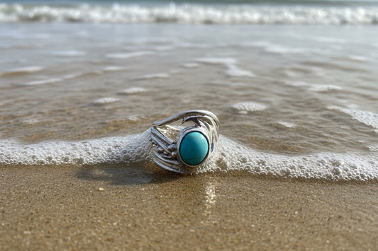 Silver ring with a turquoise stone on a gray surface