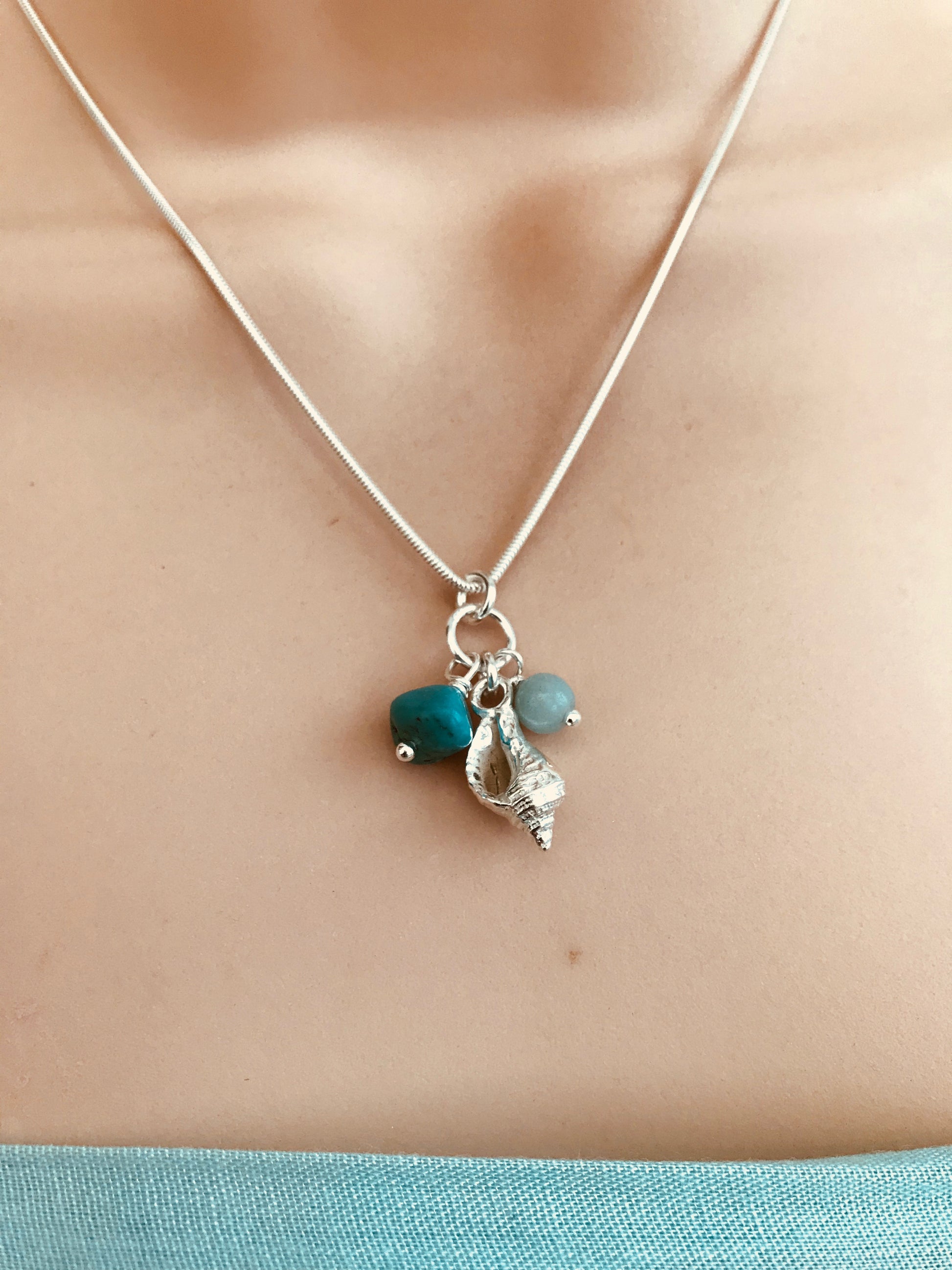 Silver whelk shell necklace with aqua coloured beads