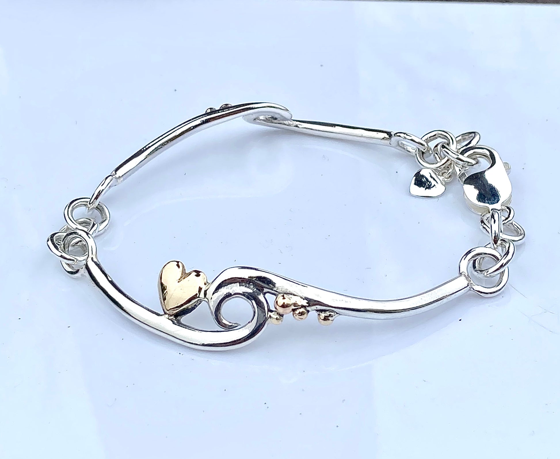 Wave silver bracelet with gold heart and pebbles