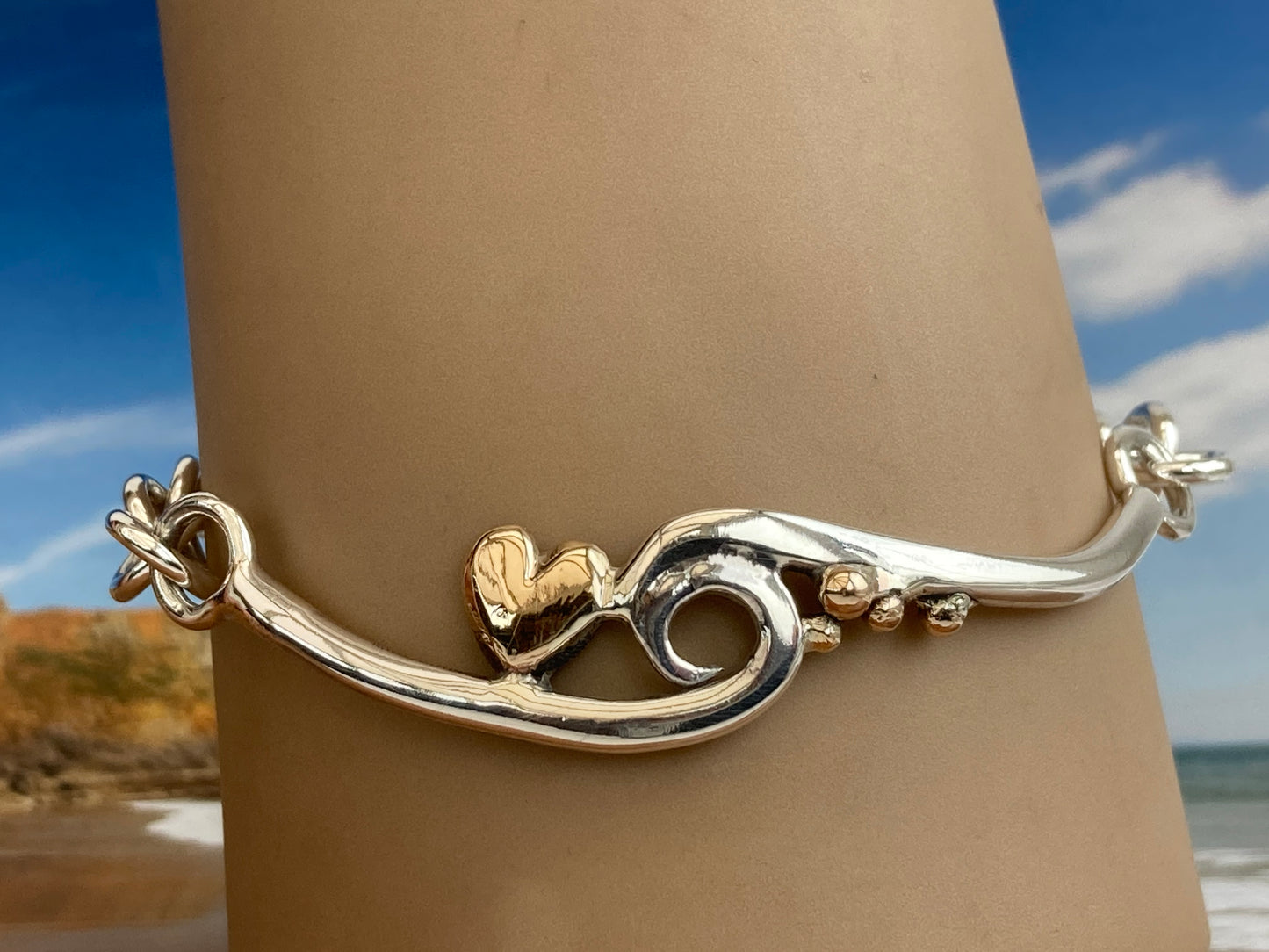 Wave silver bracelet with gold heart and pebbles