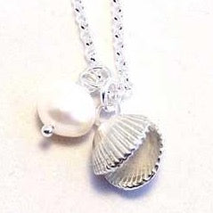 This is a unique solid silver double sided cockle shell is formed in thick silver with white pearl at it 's side 